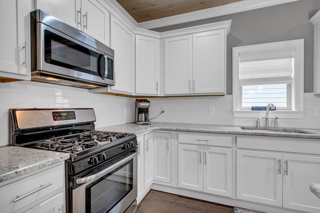 kitchen featuring light stone countertops, sink, dark hardwood / wood-style floors, white cabinets, and appliances with stainless steel finishes