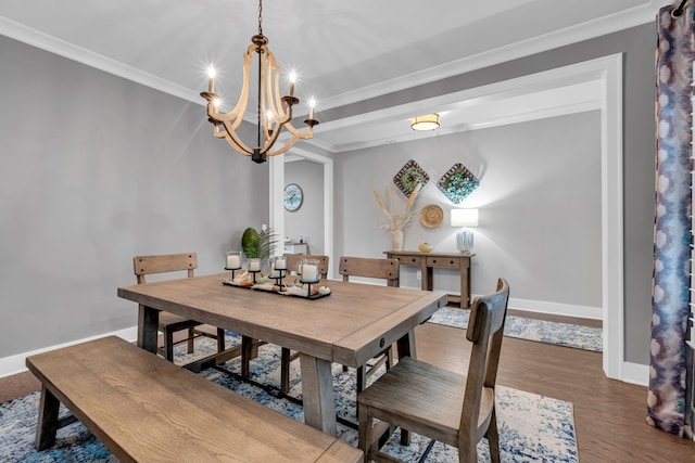 dining room with dark wood-type flooring, a chandelier, and ornamental molding