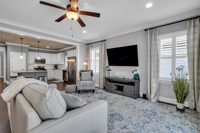 living room with hardwood / wood-style floors, ceiling fan, and crown molding