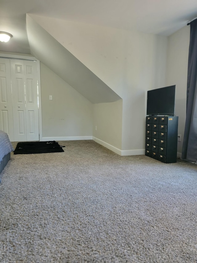 bonus room with vaulted ceiling and carpet flooring