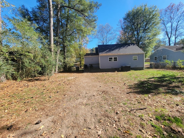 rear view of property with a yard and central air condition unit