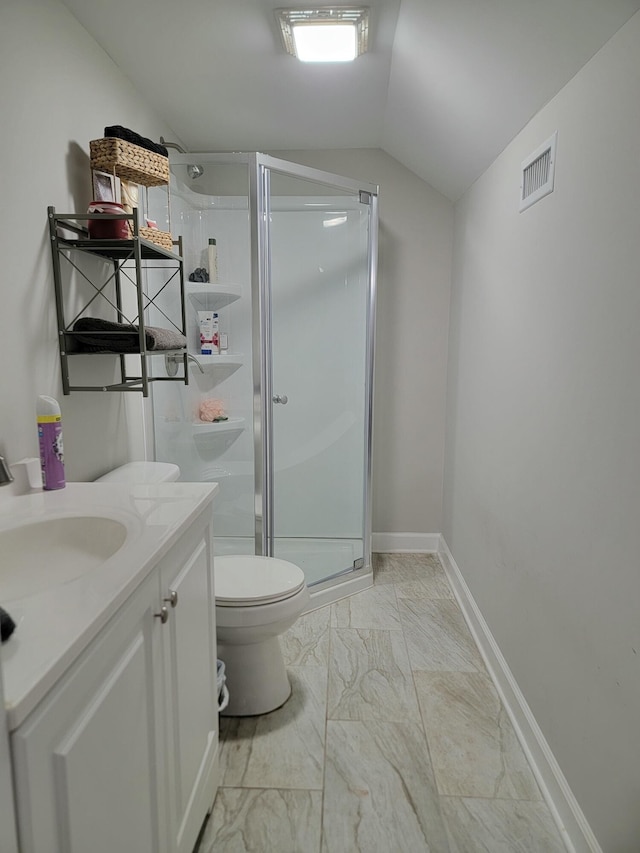 bathroom featuring lofted ceiling, vanity, a shower with shower door, and toilet