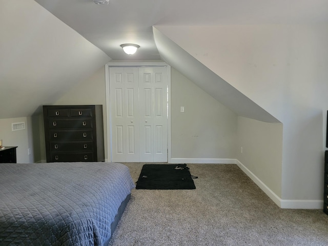 carpeted bedroom featuring vaulted ceiling and a closet