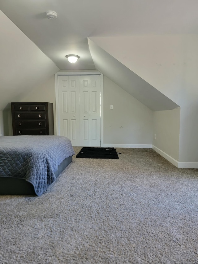 carpeted bedroom with vaulted ceiling and a closet