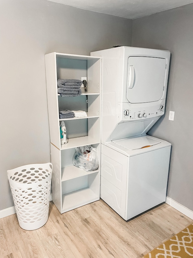 washroom with light wood-type flooring and stacked washer / drying machine