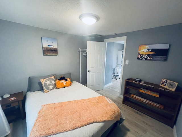 bedroom featuring hardwood / wood-style floors and a textured ceiling