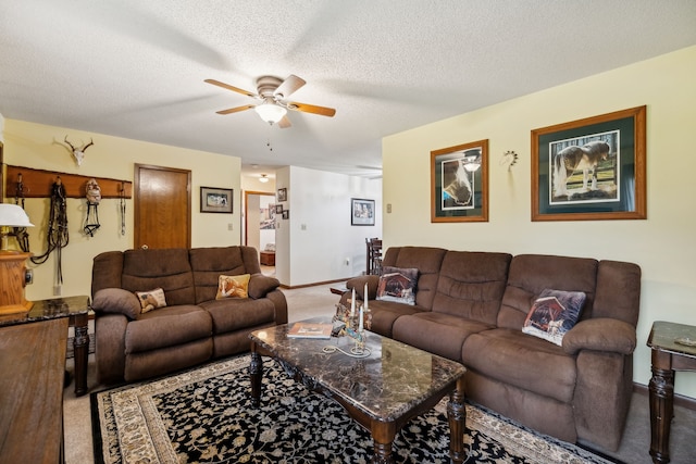 living room featuring ceiling fan, carpet, and a textured ceiling