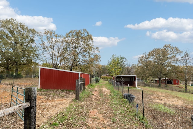 view of yard with a rural view and an outdoor structure