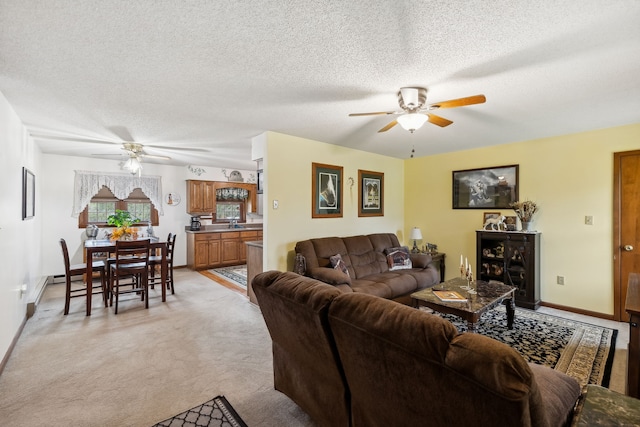 carpeted living room featuring ceiling fan, sink, and a textured ceiling