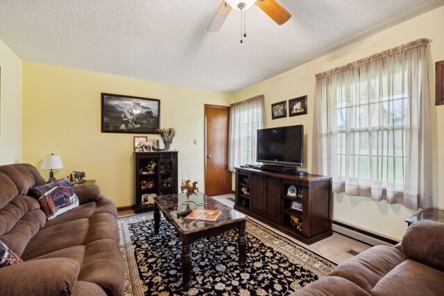 living room featuring a healthy amount of sunlight, a textured ceiling, and a baseboard radiator