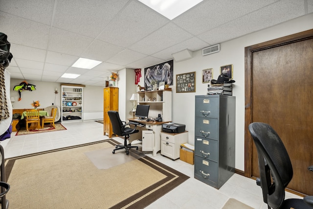 tiled office space featuring a paneled ceiling