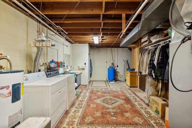 basement with washing machine and clothes dryer, water heater, and sink