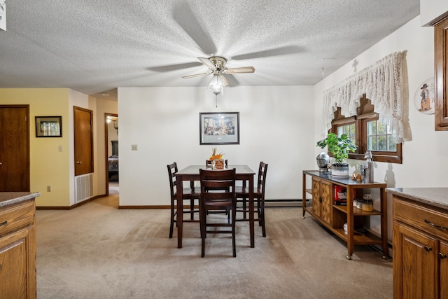 carpeted dining room with a textured ceiling and ceiling fan