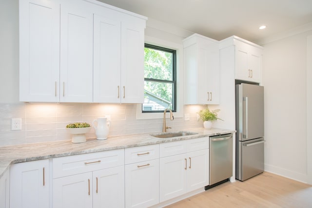 kitchen with decorative backsplash, sink, white cabinets, and appliances with stainless steel finishes