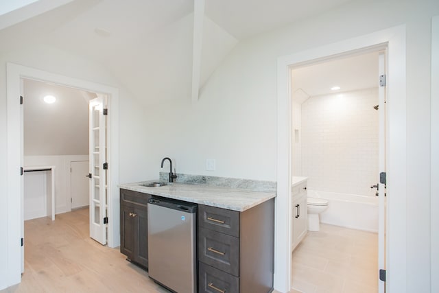 kitchen with sink, light hardwood / wood-style flooring, stainless steel fridge, light stone counters, and dark brown cabinetry