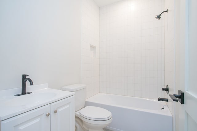 full bathroom with tiled shower / bath, vanity, and toilet