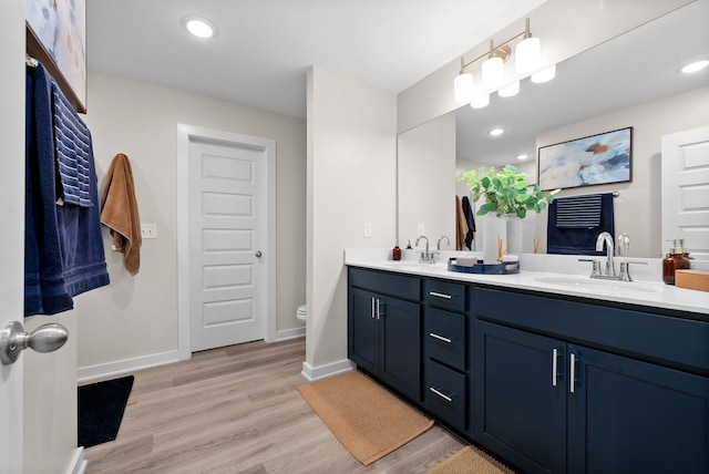 bathroom with hardwood / wood-style floors, vanity, and toilet