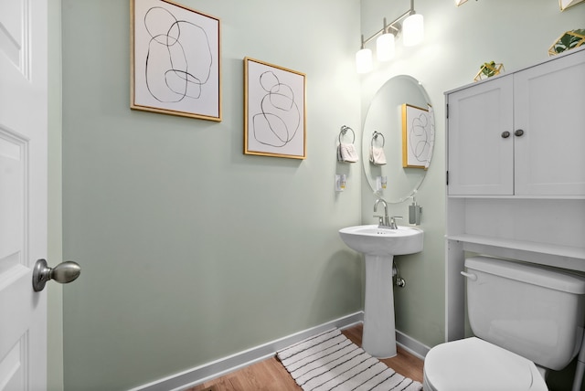 bathroom featuring sink, hardwood / wood-style floors, and toilet