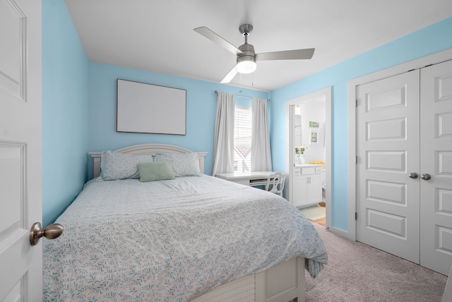 bedroom with ceiling fan, light colored carpet, connected bathroom, and a closet