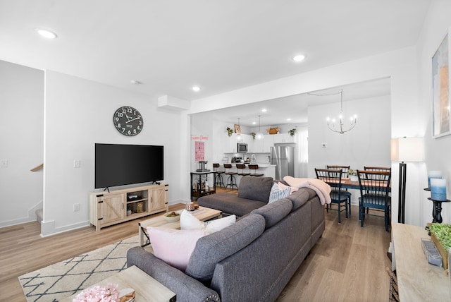 living room with a notable chandelier and light hardwood / wood-style flooring