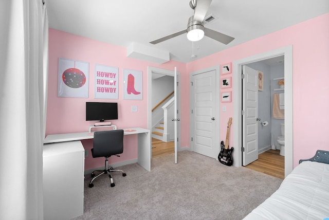 bedroom featuring light carpet, ensuite bathroom, and ceiling fan