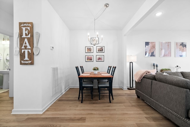 dining area featuring a notable chandelier and light hardwood / wood-style floors