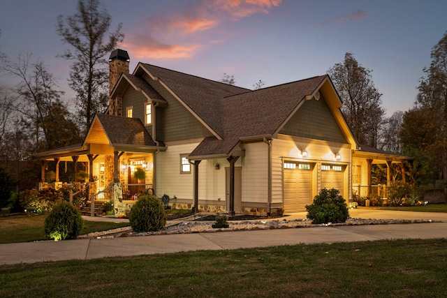 craftsman-style house with a porch, a garage, and a yard