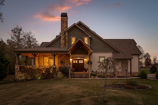 view of front of home with a porch and a lawn