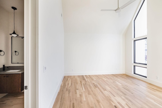 interior space with ceiling fan, light wood-type flooring, high vaulted ceiling, and sink