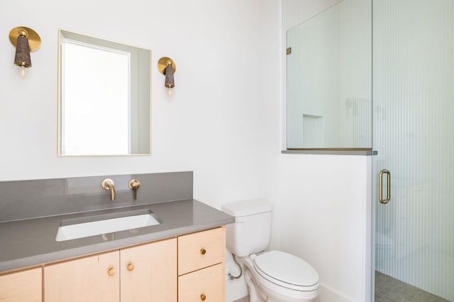 bathroom with toilet, an enclosed shower, and vanity