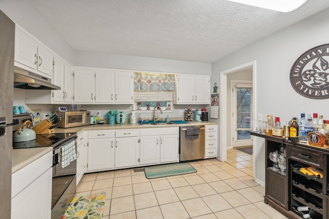 kitchen with white cabinetry, light tile patterned floors, stainless steel appliances, and a textured ceiling