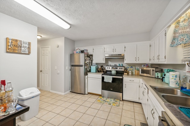 kitchen with white cabinets, light tile patterned floors, a textured ceiling, and stainless steel appliances