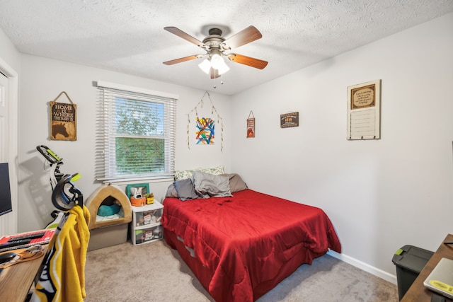 carpeted bedroom featuring ceiling fan and a textured ceiling