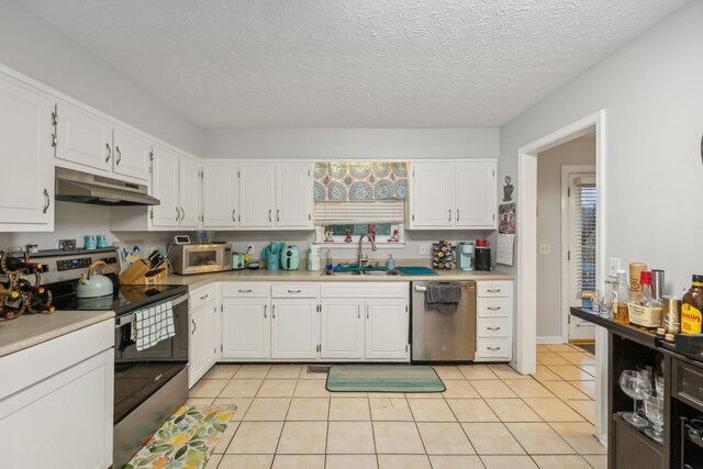 kitchen featuring white cabinetry, sink, light tile patterned floors, and stainless steel appliances