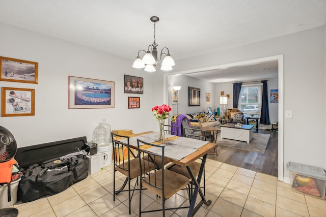 dining space featuring light hardwood / wood-style floors and an inviting chandelier