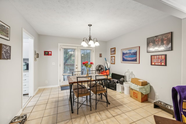 dining room with a chandelier, a textured ceiling, and light tile patterned flooring