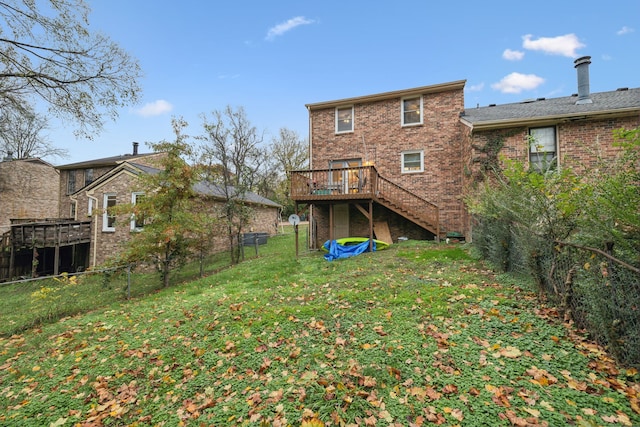 rear view of property featuring a yard and a wooden deck