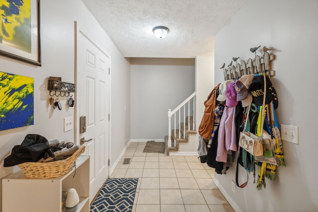 entryway featuring light tile patterned floors and a textured ceiling