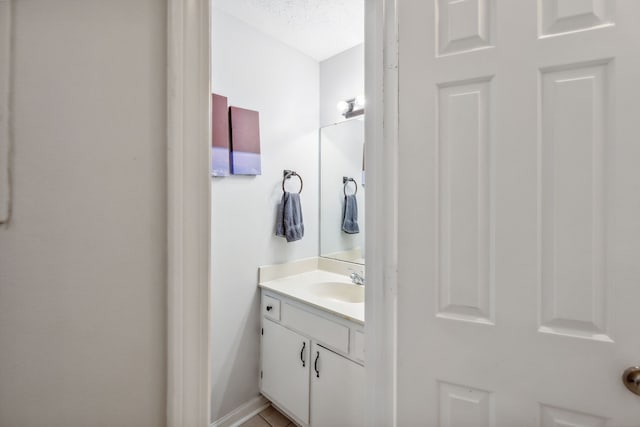 bathroom with a textured ceiling and vanity