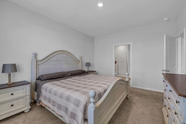 bedroom with ensuite bath and light colored carpet