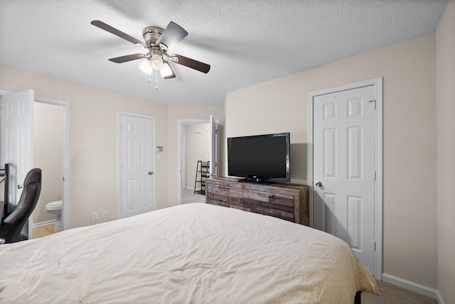 carpeted bedroom featuring connected bathroom, ceiling fan, and a textured ceiling