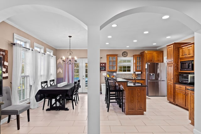 kitchen with decorative light fixtures, a healthy amount of sunlight, a notable chandelier, and appliances with stainless steel finishes