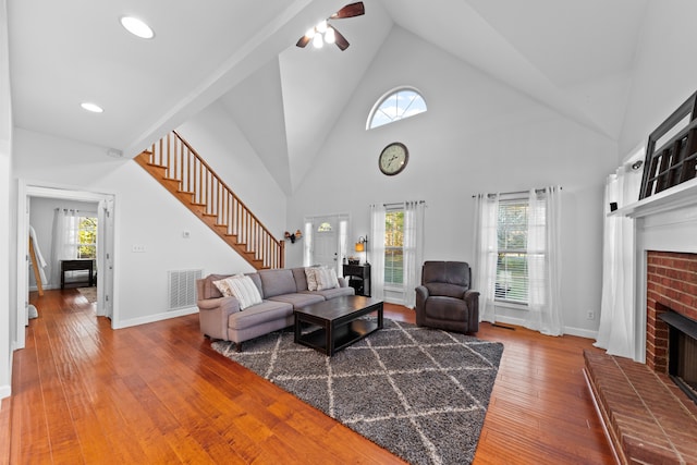 living room with plenty of natural light, hardwood / wood-style floors, and a brick fireplace