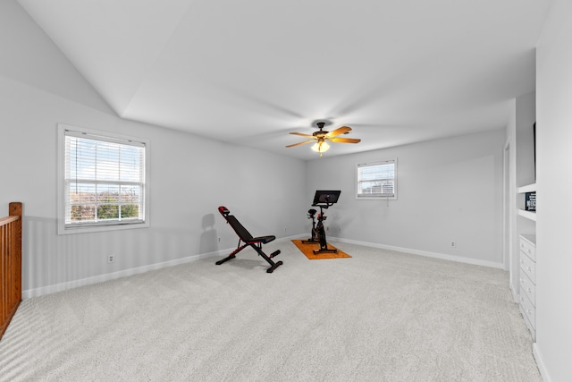 workout area featuring ceiling fan, light colored carpet, and vaulted ceiling