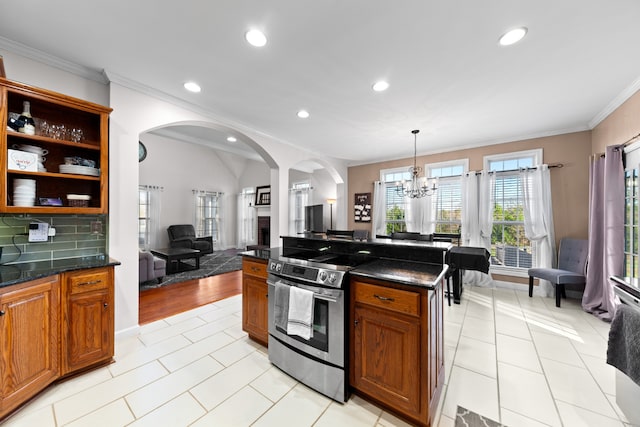 kitchen featuring backsplash, stainless steel electric stove, ornamental molding, light tile patterned floors, and a chandelier