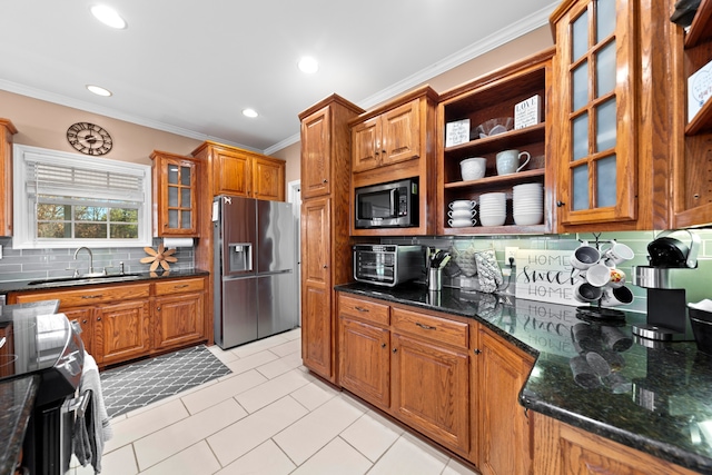 kitchen with sink, crown molding, dark stone counters, decorative backsplash, and appliances with stainless steel finishes