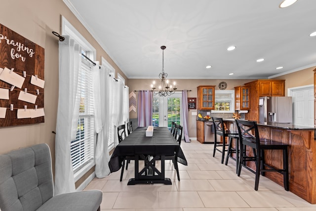 tiled dining space featuring ornamental molding and an inviting chandelier