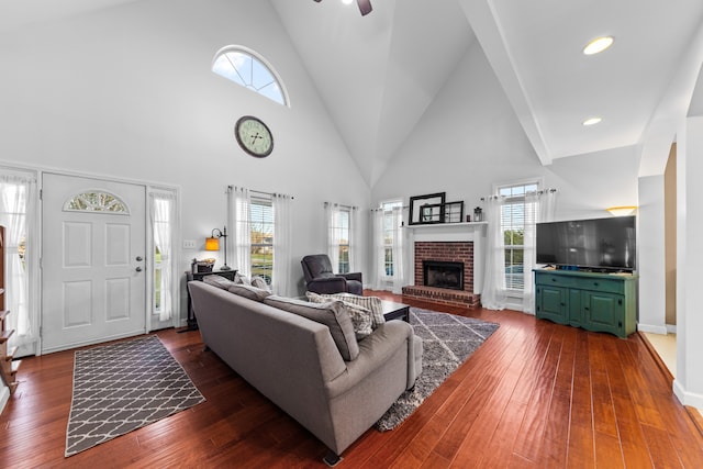 living room with high vaulted ceiling, plenty of natural light, dark wood-type flooring, and ceiling fan