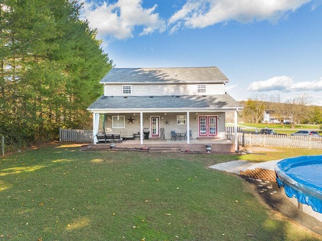 back of property featuring french doors, a yard, a covered pool, and a patio area