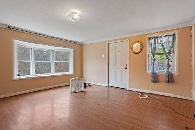 unfurnished room featuring hardwood / wood-style floors and ornamental molding